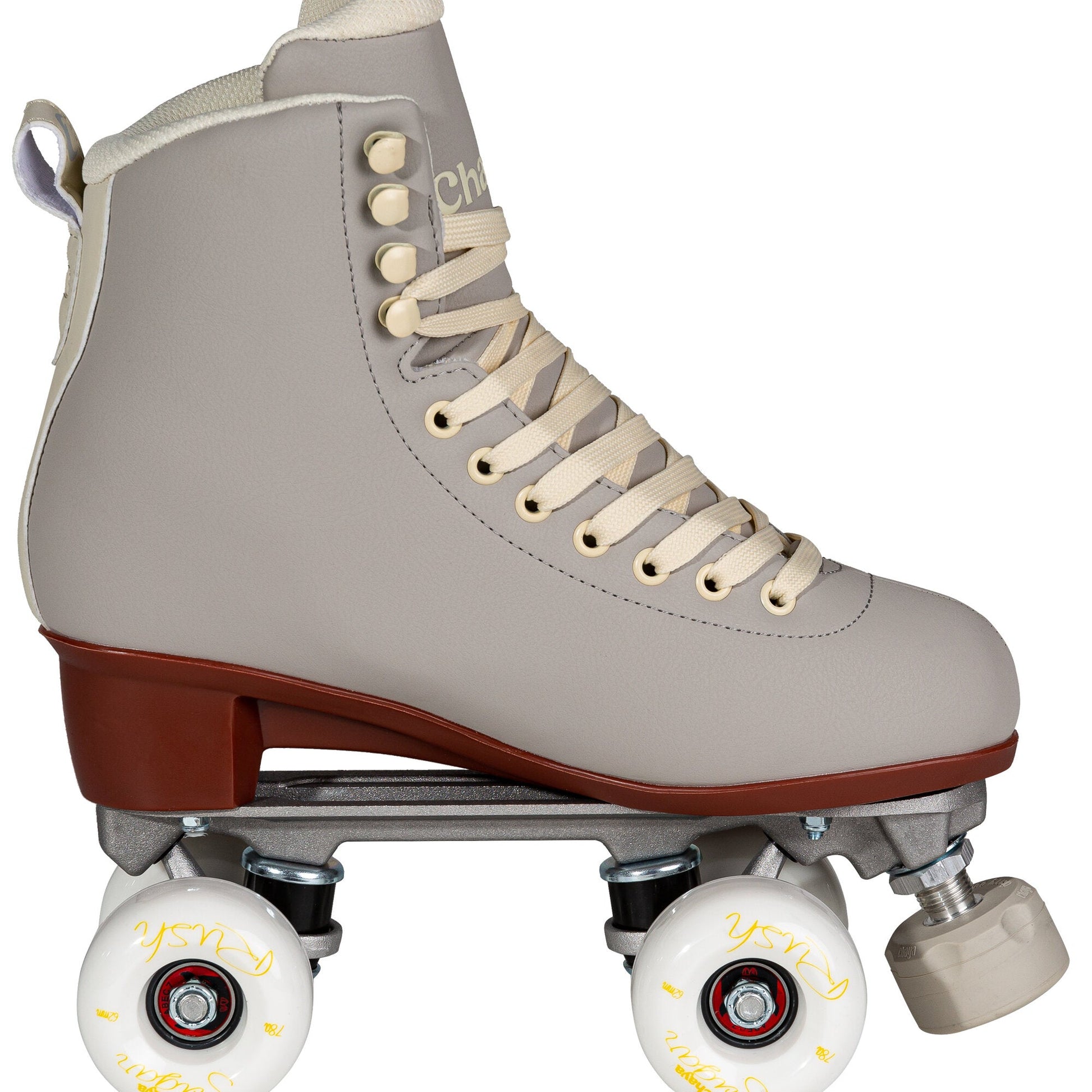 View of a Chaya Melrose Deluxe Latte quad skate from the side, showcasing its full boot, wheel, and plate assembly in the signature latte color.